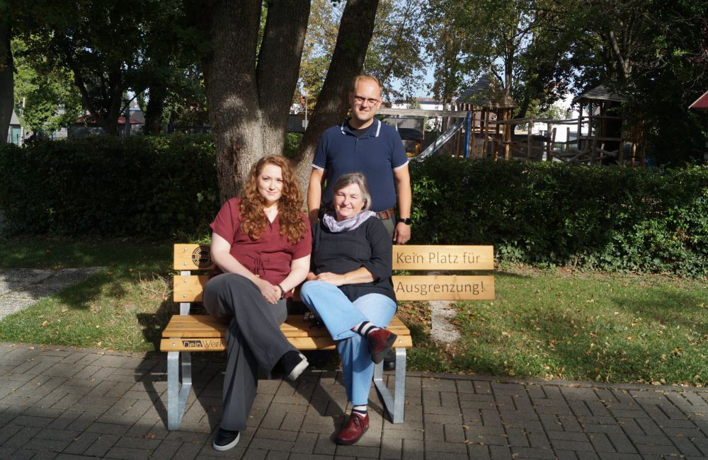 Zwei Personen halten ein Schild mit dem Logo der SekAE
