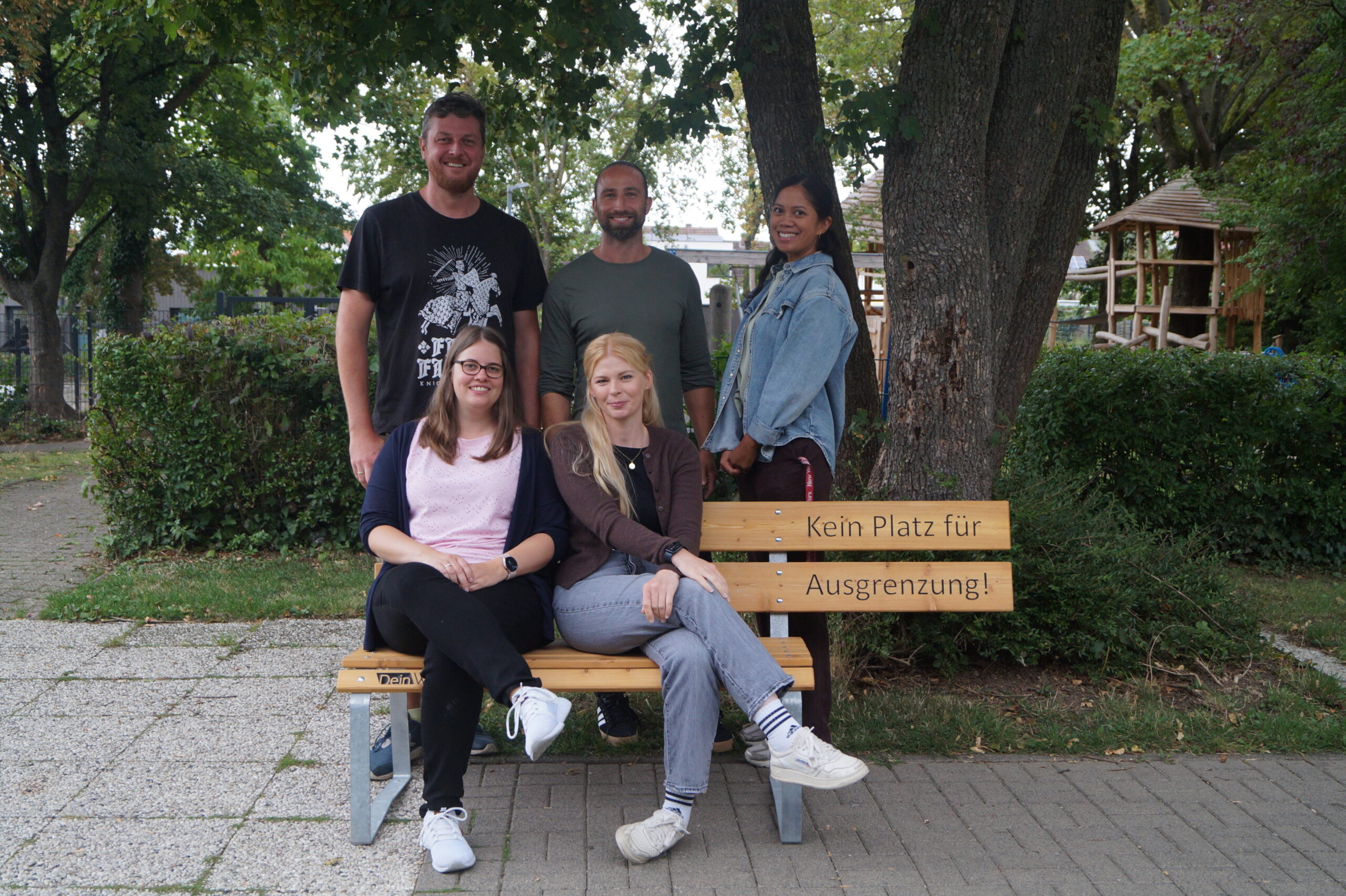 Drei Personen halten ein Schild mit dem Logo der SekAE
