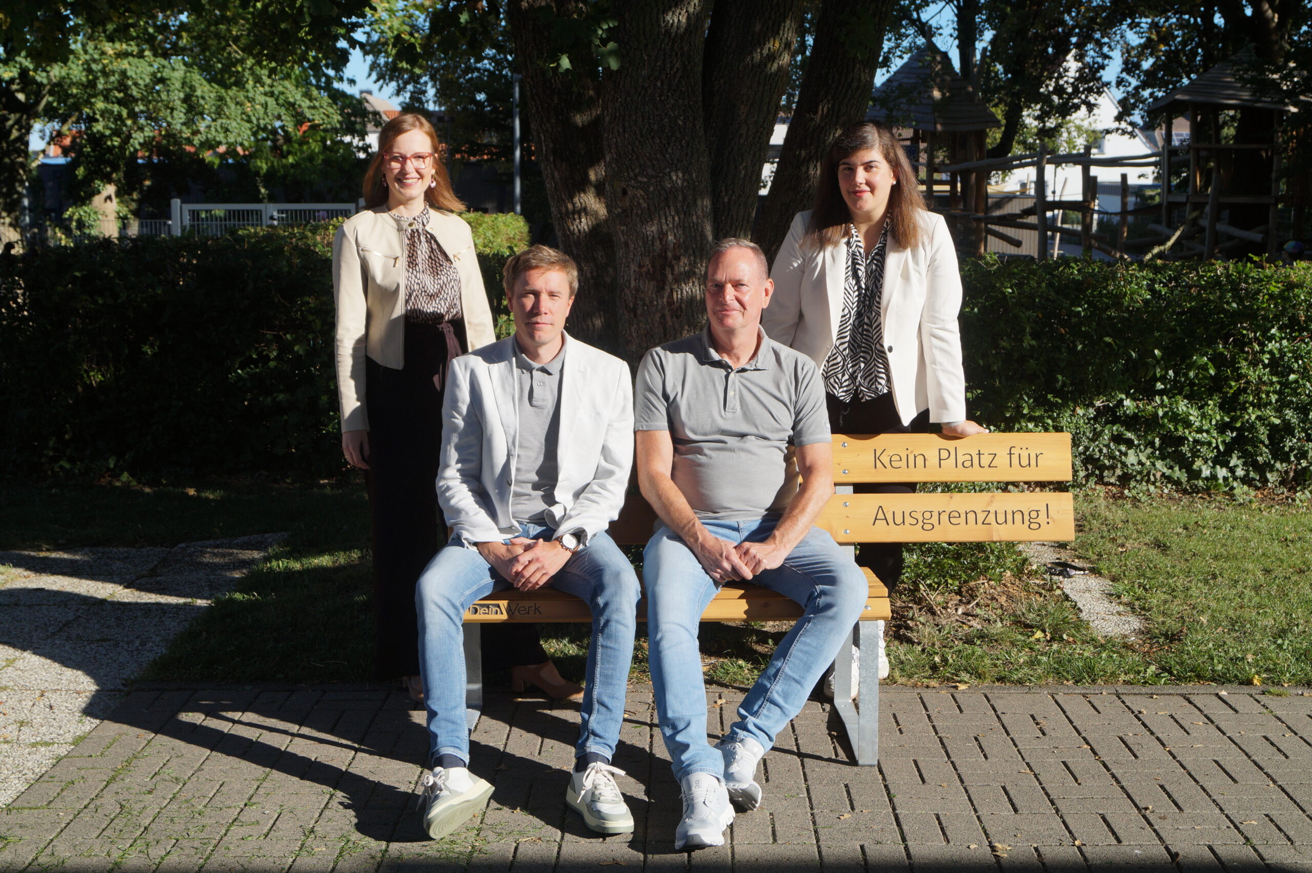 Vier Personen halten ein Schild mit dem Logo der SekAE